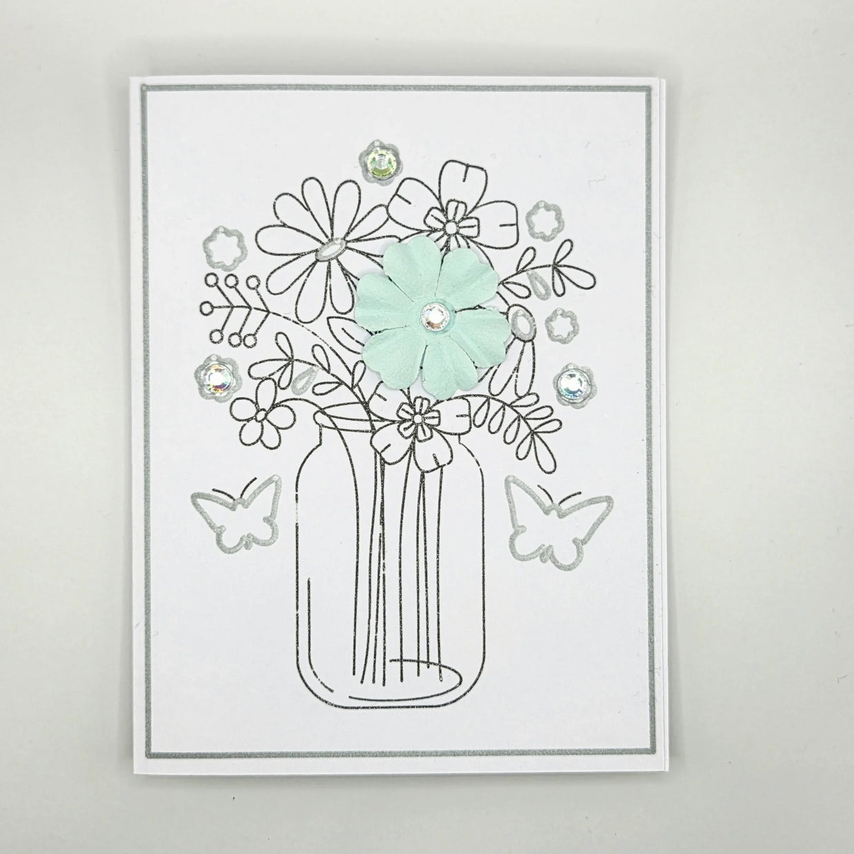 Handmade card with mason jar flower bouquet, pastel flower, rhinestones, and butterfly accents