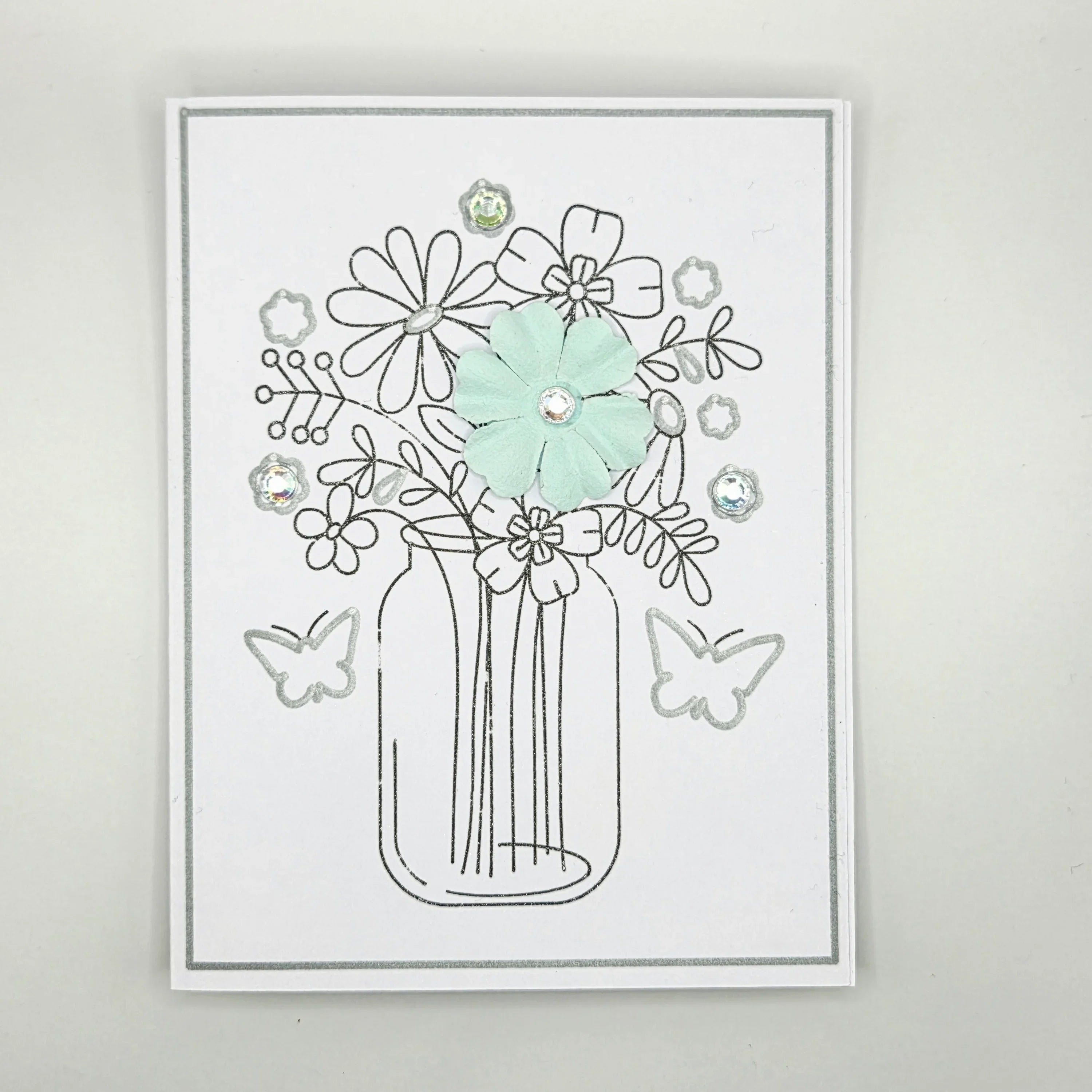 Handmade card with mason jar flower bouquet, pastel flower, rhinestones, and butterfly accents