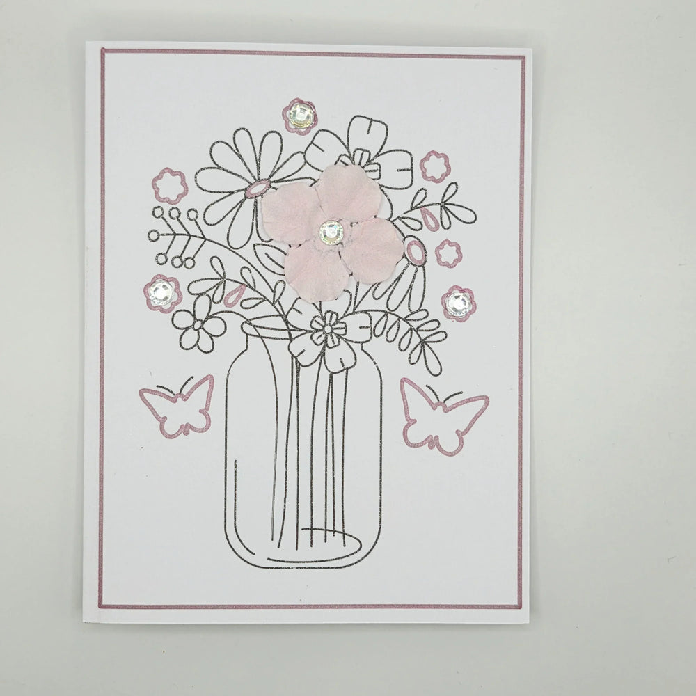Handmade floral card with glittery vase, pink flowers, butterflies, and rhinestone accents for cozy gifts