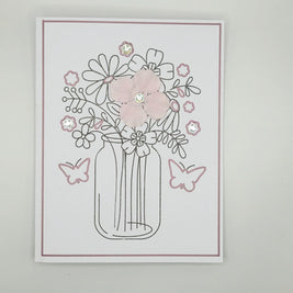 Handmade floral greeting card with pink fabric flowers, butterflies, and glitter accents