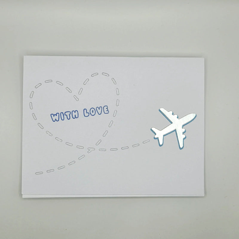 Handmade card with airplane flying into heart shape, 'WITH LOVE' text, perfect for travel-themed gifts