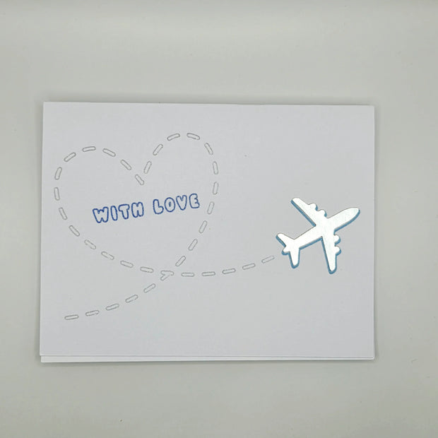 Handmade greeting card with silver airplane and heart-shaped flight path, text 'With Love'.