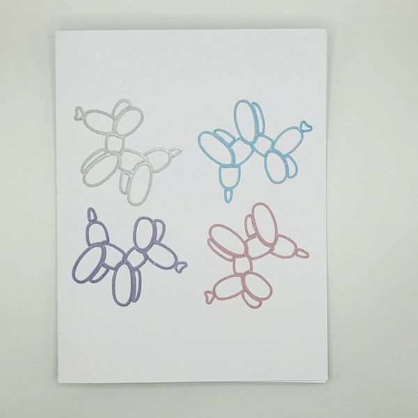 Four glittery balloon animal designs in silver, blue, purple, and pink on white paper