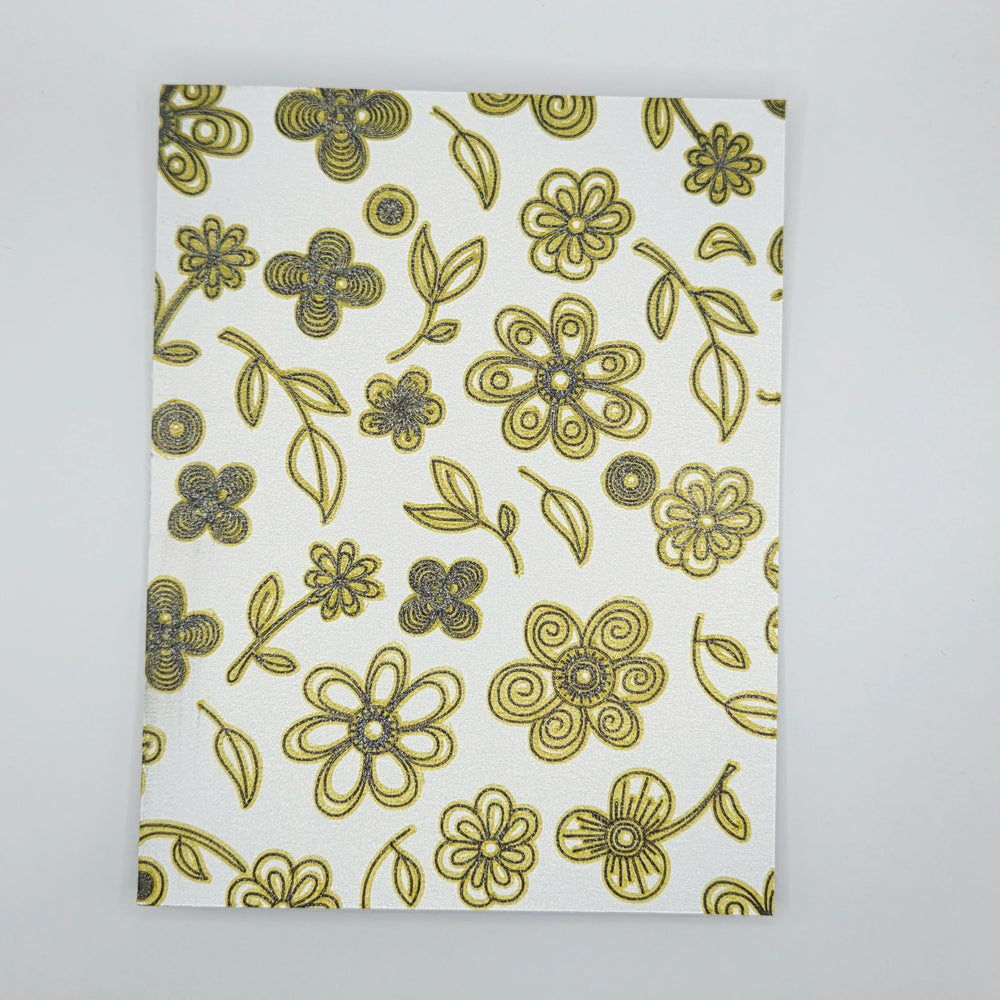 White fabric with gold and silver glitter floral pattern, ideal for handmade crochet gifts and cozy decor