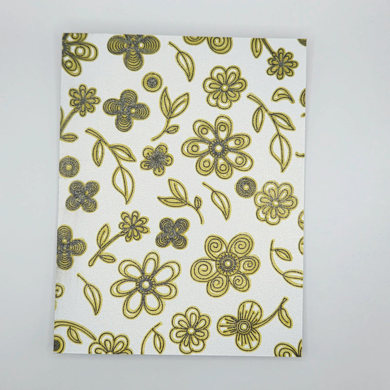 White fabric with gold and silver glitter floral pattern, ideal for handmade crochet gifts and cozy decor
