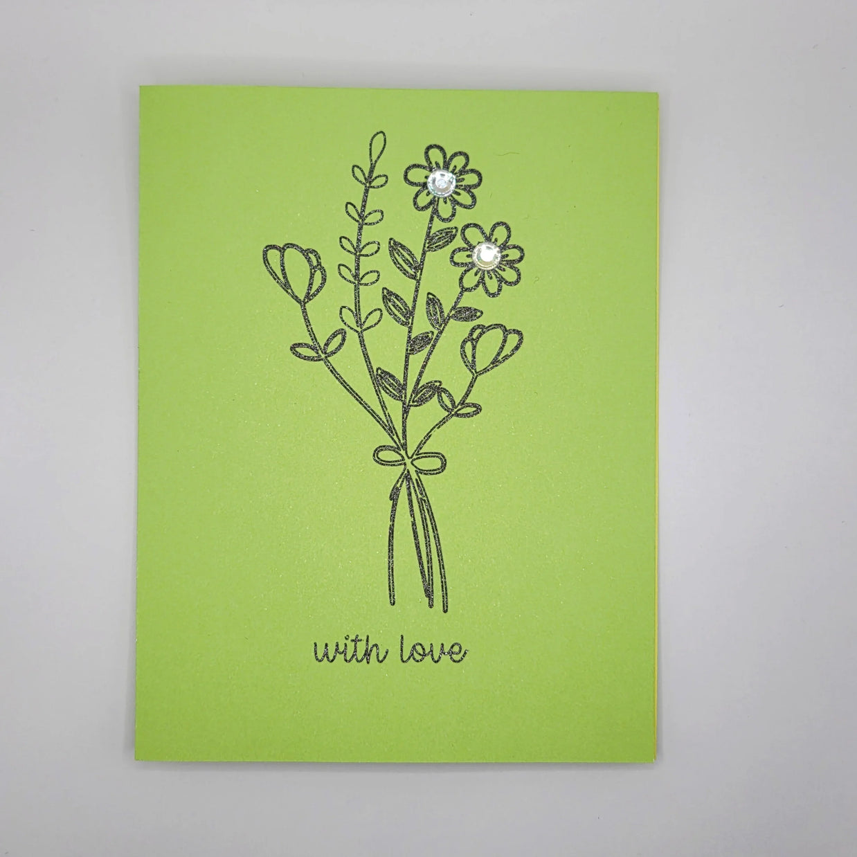 Handmade green greeting card with a black floral bouquet and 'with love' message, embellished with gems.