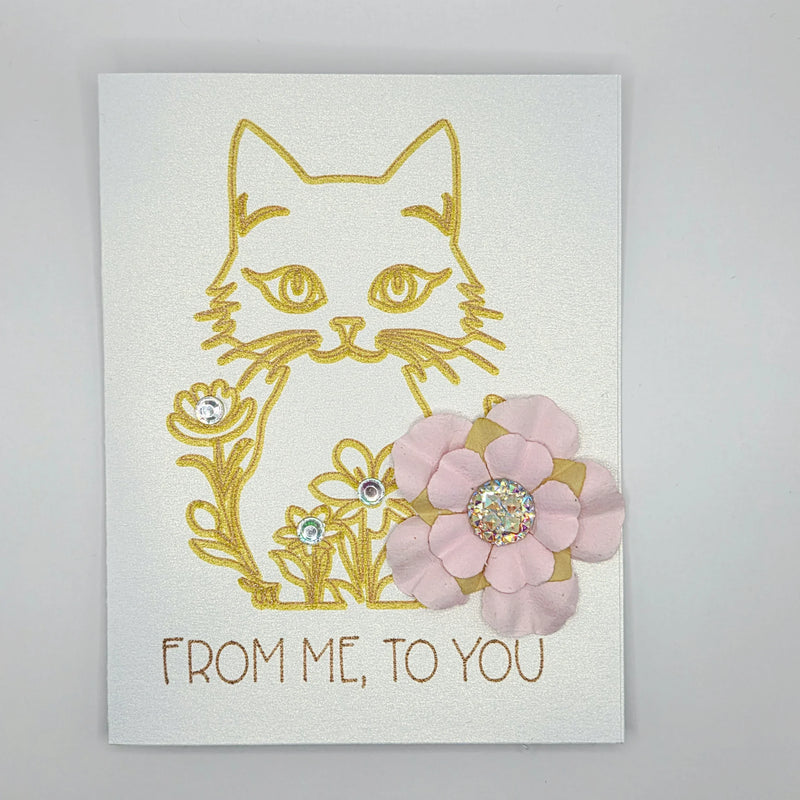 Handmade cat card with gold glitter outline, pink paper flower, and rhinestones, saying 'FROM ME, TO YOU'