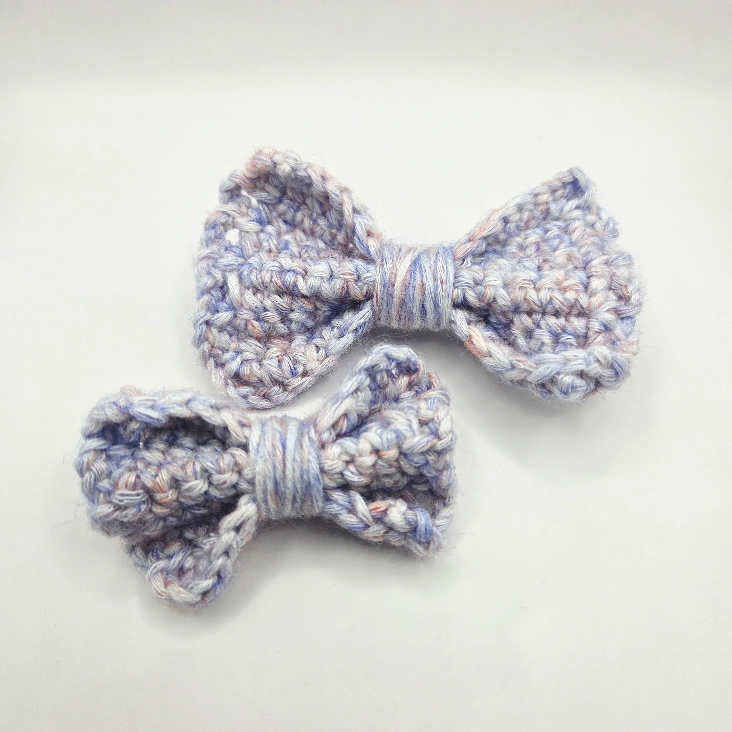 Handmade crochet bows in soft pastel yarn, perfect for cozy gifts and creative styling.