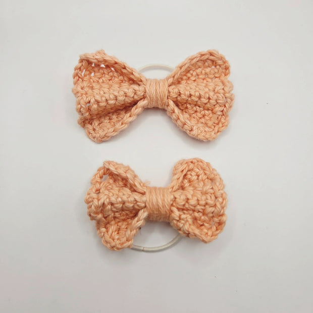 Handmade crochet peach bow hair ties on white background, Erika Liesel cozy gift