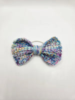 Handmade crochet bow hair tie in pastel multicolor yarn, cozy and creative accessory