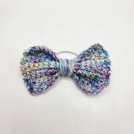 Handmade crochet bow hair tie in pastel multicolor yarn, cozy and creative accessory