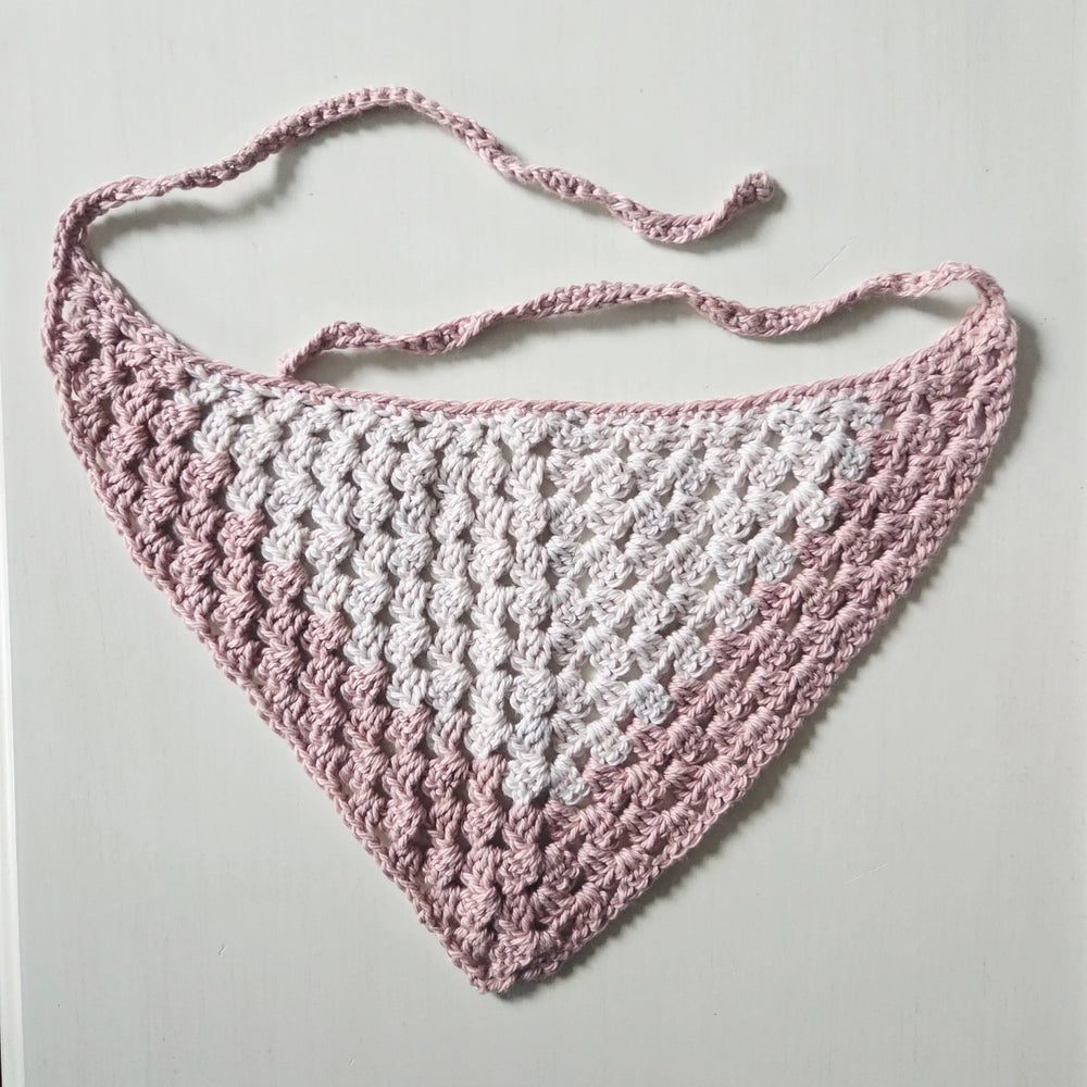Handmade crochet baby bib in soft pink and white, cozy and breathable design for infants