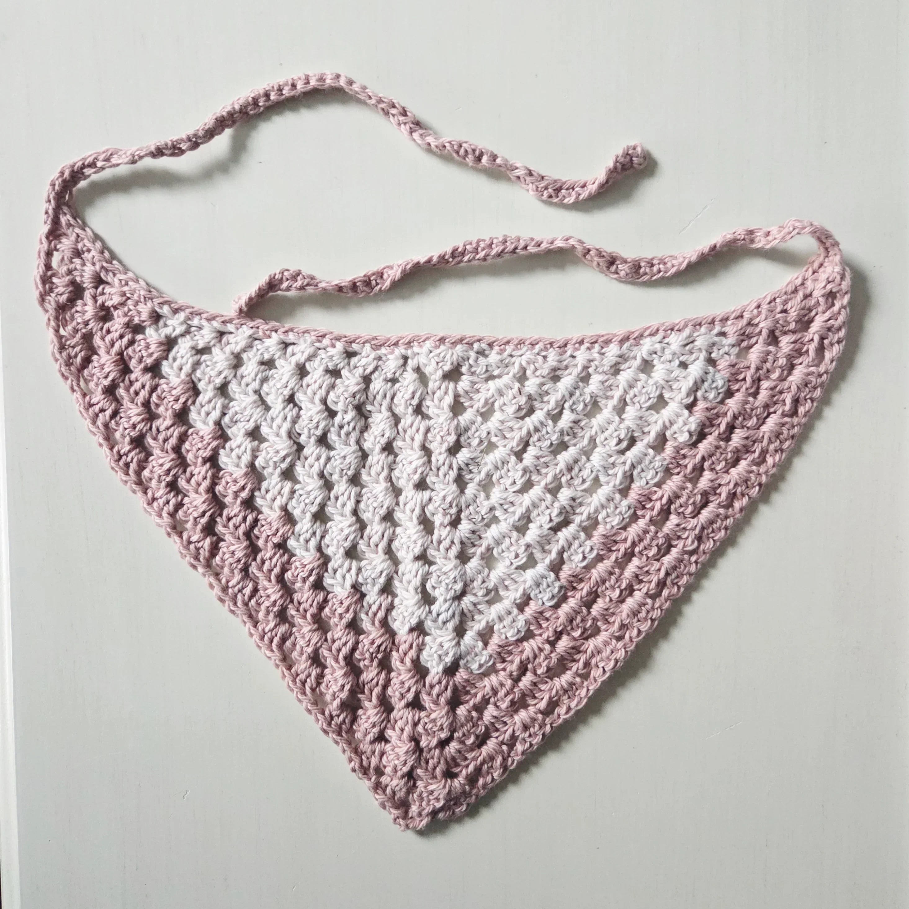 Handmade crochet triangle scarf in pink and white, perfect for cozy, creative gifting.