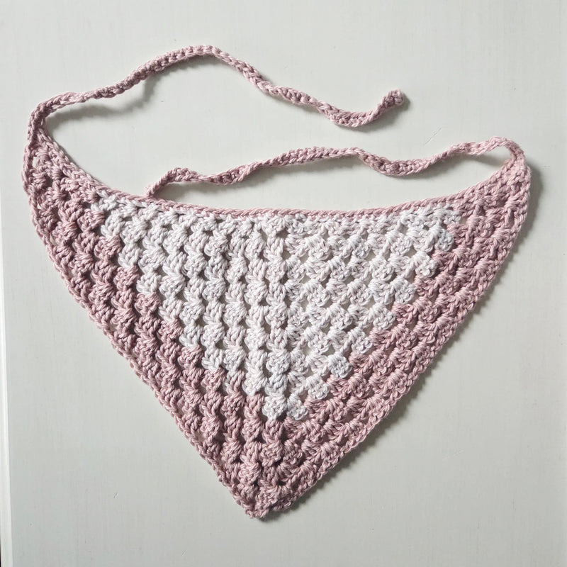 Handmade crochet baby bib in soft pink and white, cozy and breathable design for infants