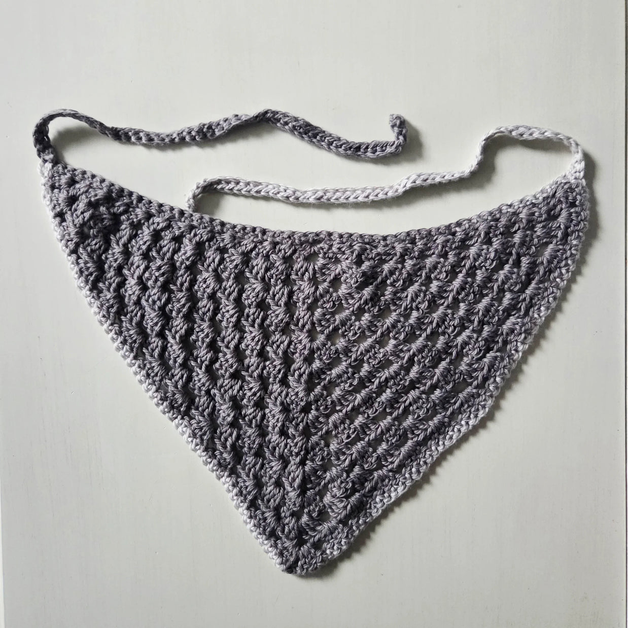 Handmade gray crochet triangle scarf with delicate lace pattern and adjustable ties
