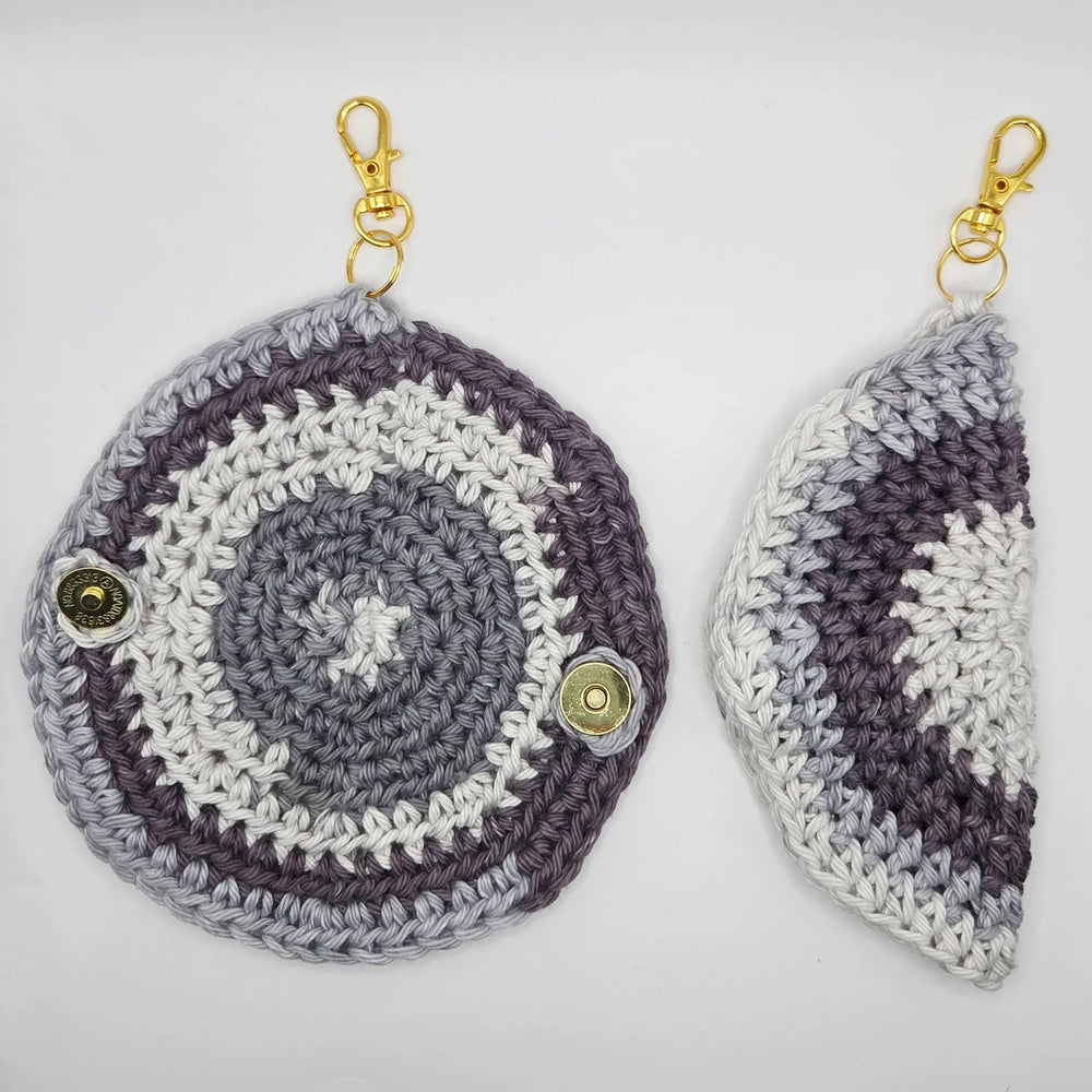 Handmade crochet keychain pouches in gray, white, and purple with gold snap closures and lobster clasps