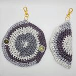 Handmade crochet keychain pouches in gray, white, and purple with gold snap closures and lobster clasps