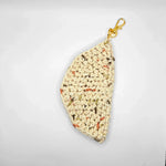 Handmade crochet keychain pouch with speckled yarn and gold clasp, cozy and creative accessory