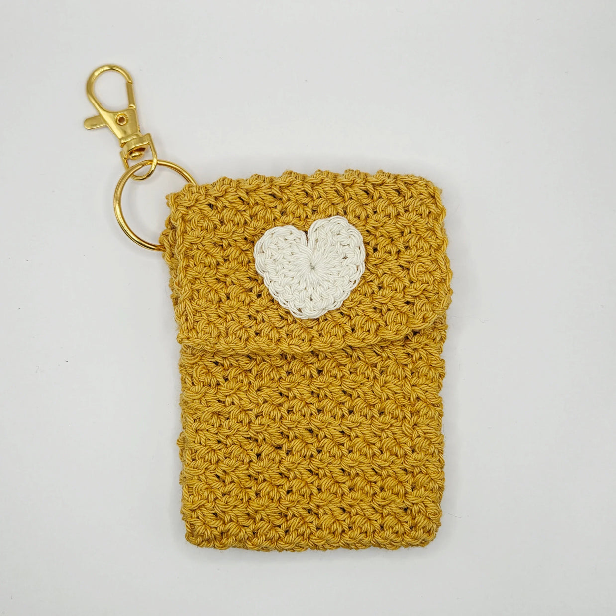 Handmade mustard yellow crochet pouch with white heart and gold keychain clip