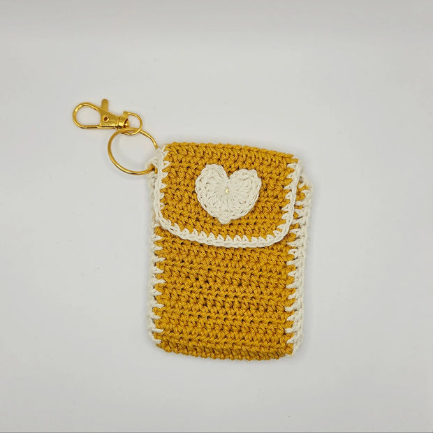 Handmade mustard yellow crochet pouch with white heart and keychain, by Erika Liesel
