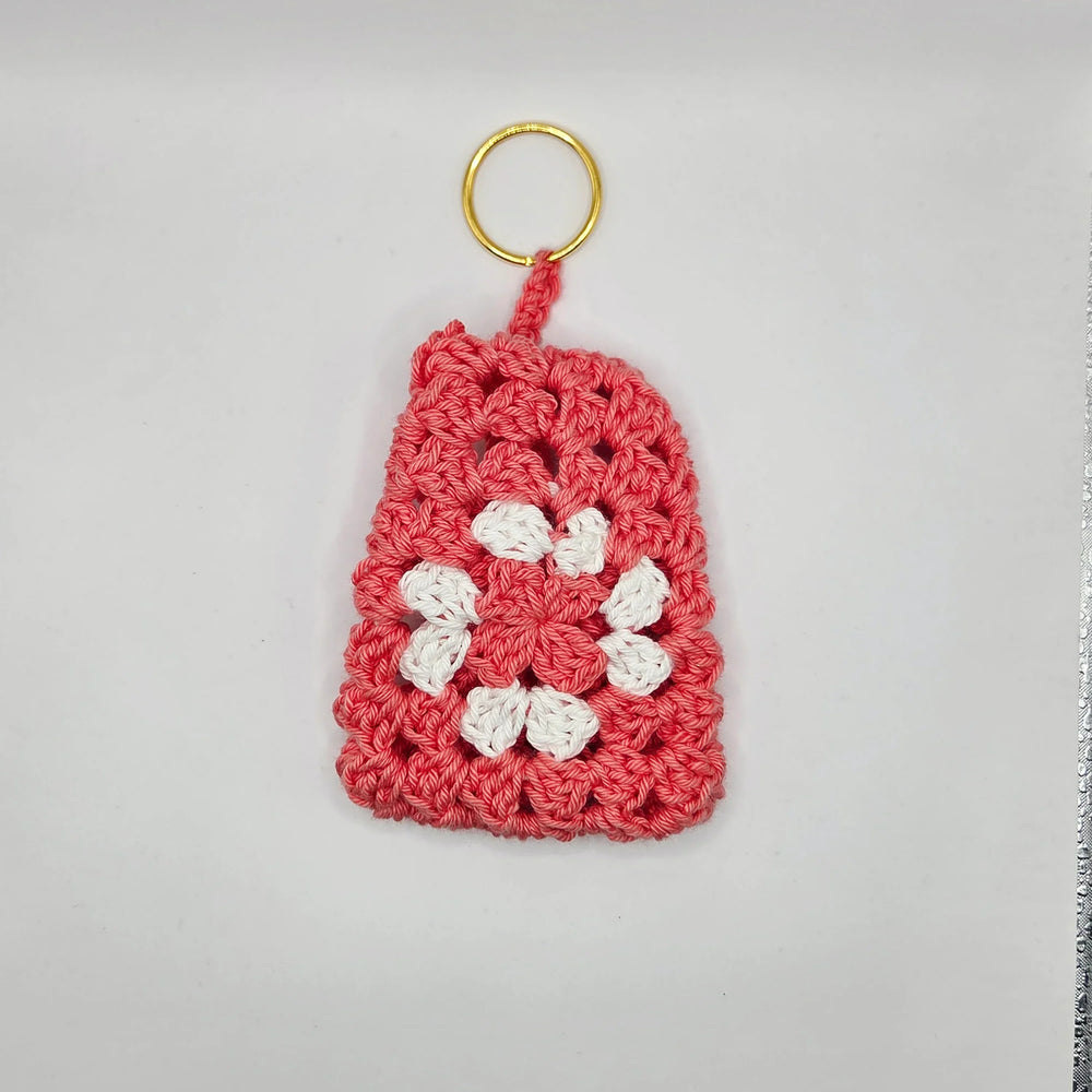 Handmade crochet keychain with pink base and white flower, cozy craft gift