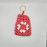 Handmade crochet keychain with pink base and white flower, cozy craft gift