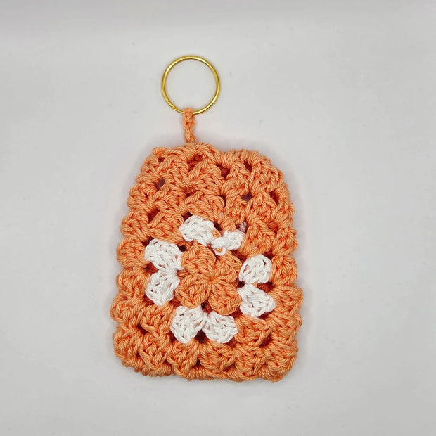Handmade orange and white crochet keychain with floral pattern by Erika Liesel