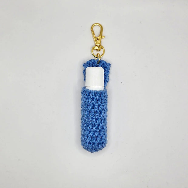 Blue handmade crochet lip balm holder keychain with gold clasp on white background