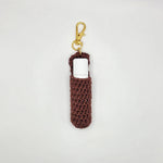 Handmade crochet lip balm holder with gold clip, cozy brown yarn, perfect for everyday use