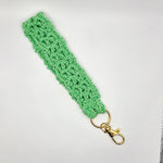 Handmade mint green crochet keychain with gold clasp, cozy and creative accessory