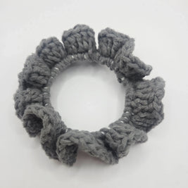 Handmade grey crochet scrunchie with ruffled edges on white background