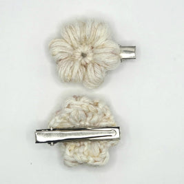 Handmade crochet flower hair clips in cream yarn with silver clasps on white background