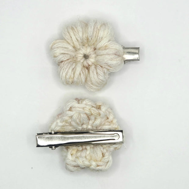 Handmade crochet flower hair clips in cream yarn with silver clasps on white background