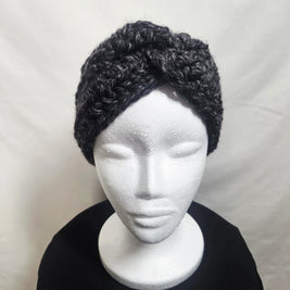 Handmade chunky crochet headband in dark yarn on white mannequin, cozy winter accessory