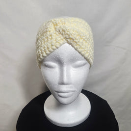 Handmade crochet cream headband on mannequin, cozy accessory by Erika Liesel