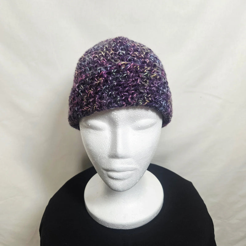 Handmade crochet beanie in purple and pink variegated yarn, cozy winter hat on mannequin