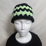 Handmade crochet hat with black and mint green chevron pattern, cozy winter beanie on mannequin