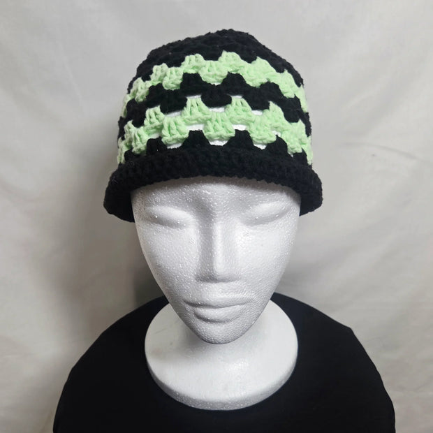 Handmade crochet bucket hat in black and green on mannequin, cozy gift by Erika Liesel