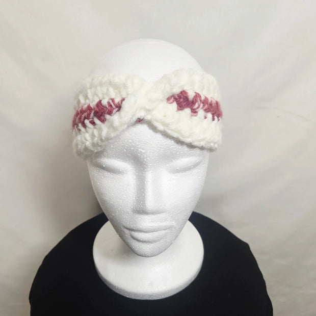 Handmade crochet headband with white and pink yarn on mannequin, cozy gift by Erika Liesel