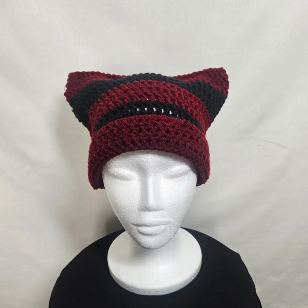 Handmade crochet cat ear hat in red and black on mannequin, cozy knit gift by Erika Liesel