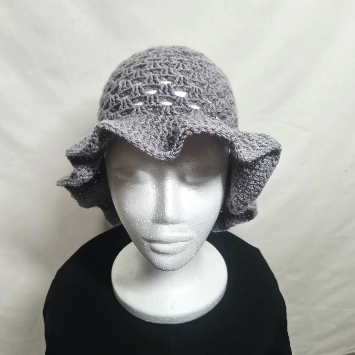Handmade gray crochet ruffle hat on mannequin, cozy accessory by Erika Liesel