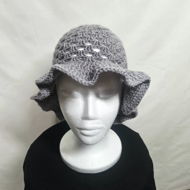 Handmade gray crochet ruffle hat on mannequin, cozy accessory by Erika Liesel