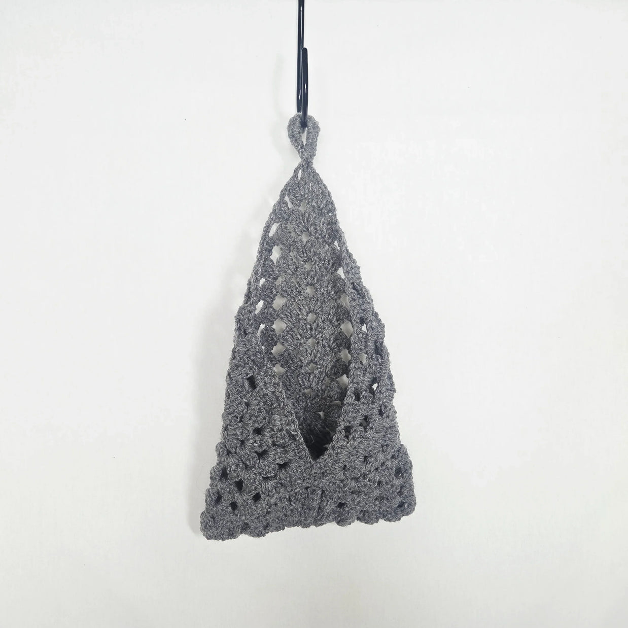 Handmade grey crochet hanging pouch against a plain white background