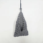 Handmade gray crochet triangle wall hanging with openwork pattern, perfect for cozy home decor.