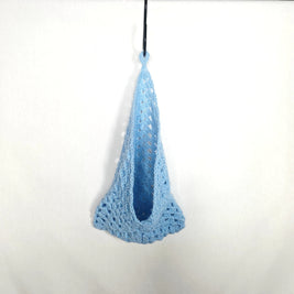 Handmade light blue crochet bag hanging on white background, cozy and creative gift