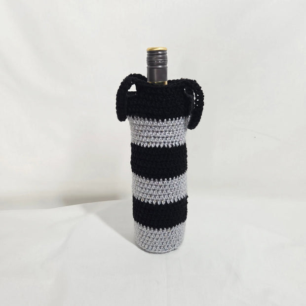 Handmade black and gray striped crochet wine bottle cover with handles on white background