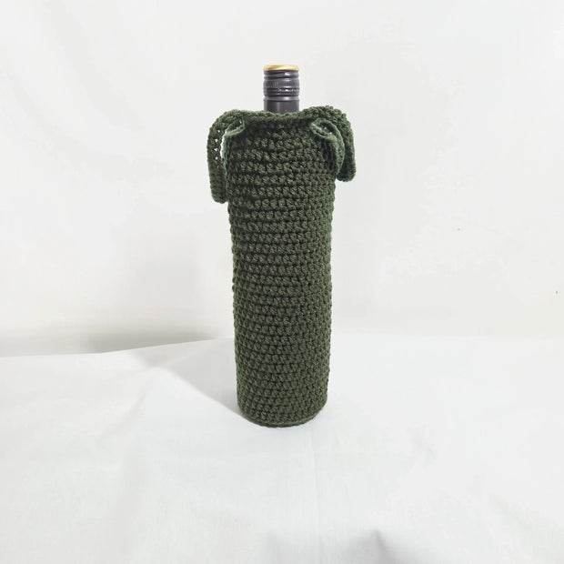 Handmade crochet bottle cover in dark green, displayed upright on a white background.