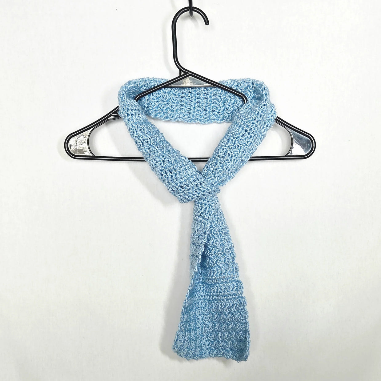 Handmade light blue crochet scarf on hanger, cozy gift by Erika Liesel