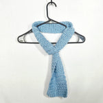Light blue handmade crochet scarf draped on black hanger, cozy and soft textured knit for everyday comfort