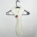 Handmade white crochet scarf with red flower accent, cozy winter accessory on hanger